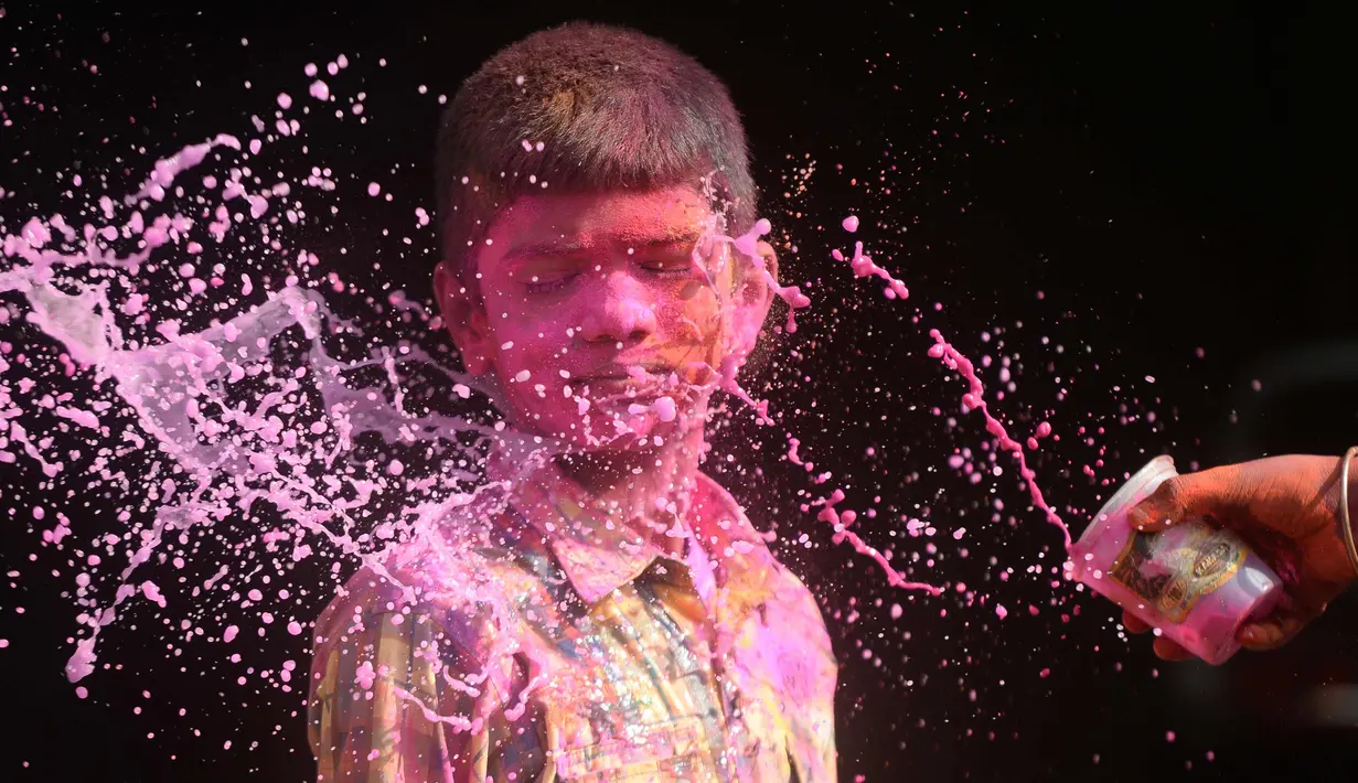 Seorang anak India terkena air berwarna selama perayaan festival Holi di Chennai (2/3). Holi, festival musim semi hindu di India yang diadakan 2 Maret tahun ini pada akhir musim dingin pada bulan purnama pertama kalender lunar. (AFP Photo/Arun Sankar)