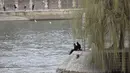 Orang-orang duduk di tepi sungai Seine di Paris, Rabu (3/3/2021).  Tingkat infeksi COVID-19 tetap tinggi selama beberapa minggu, dan pasien virus menempati 70% unit perawatan intensif negara itu. (AP Photo/Lewis Joly)