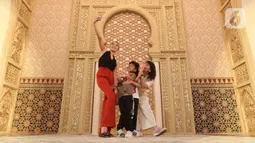 Pengunjung berswafoto saat melihat-lihat instalasi Istana Alhambra di Mal Senayan City, Jakarta Pusat, Kamis (15/4/2022). Instalasi megah setinggi 14 meter itu merupakan perwujudan dari tema The Divine Ramadan yang dibuat untuk menyemarakkan bulan puasa. (Liputan6.com/Herman Zakharia)