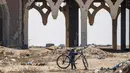 Seorang anak bermain di depan terminal "Yasser Arafat International Airport" yang hancur dan sepi di Jalur Gaza, di kota Rafah, Palestina (24/6/2019). Otoritas Palestina menyatakan sudah memboikot pertemuan di Bahrain yang akan dimulai pada Selasa (25/6) pekan depan. (AFP Photo/Said Khatib)