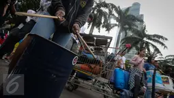 Atraksi pagelaran musik menggunakan barang-barang bekas di Car Free Day kawasan Bundaran HI, Jakarta, Minggu (15/1). (Liputan6.com/Faizal Fanani)