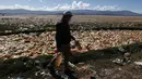Limbert Sanchez, anggota Pusat Ekologi dan Masyarakat Andes, membawa botol yang diambil dari lautan sampah yang memenuhi Sungai Tagaret, Bolivia, yang kering, Kamis (25/3/2021). Sungai ini mengalir ke Danau Uru Uru dengan membawa sampah-sampah yang mencemari danau. (AP Photo / Juan Karita)