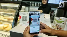 Warga melakukan transaksi pembayaran dengan QRIS Gopay Tabungan by Jago saat berbelanja di Jakarta, Rabu (7/2/2024). (Liputan6.com/Angga Yuniar)