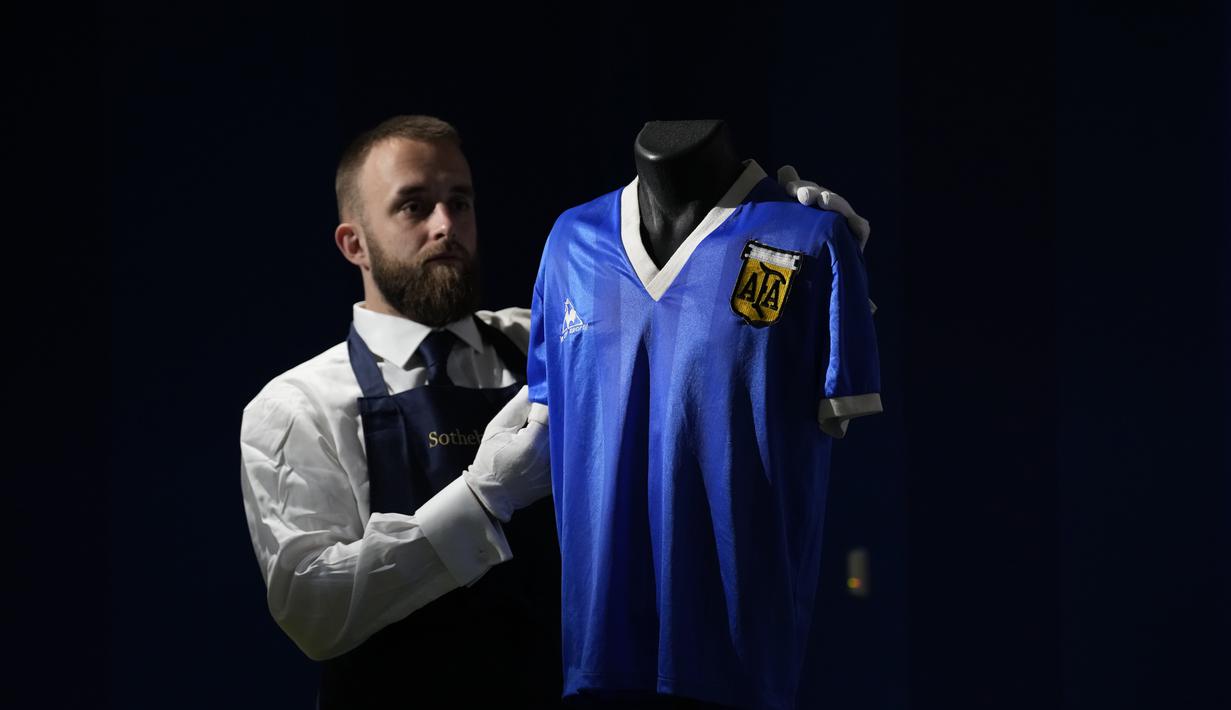 <p> Jersey Argentina yang dikenakan Diego Maradona dalam pertandingan perempat final Piala Dunia Meksiko 1986 antara Argentina dan Inggris, dipajang untuk difoto di rumah lelang Sotheby's, di London, Rabu (20/4/2022). Baju yang dijual secara online lelang  berlangsung dari 20 April hingga 4 Mei. (AP Photo/Matt Dunham)</p>