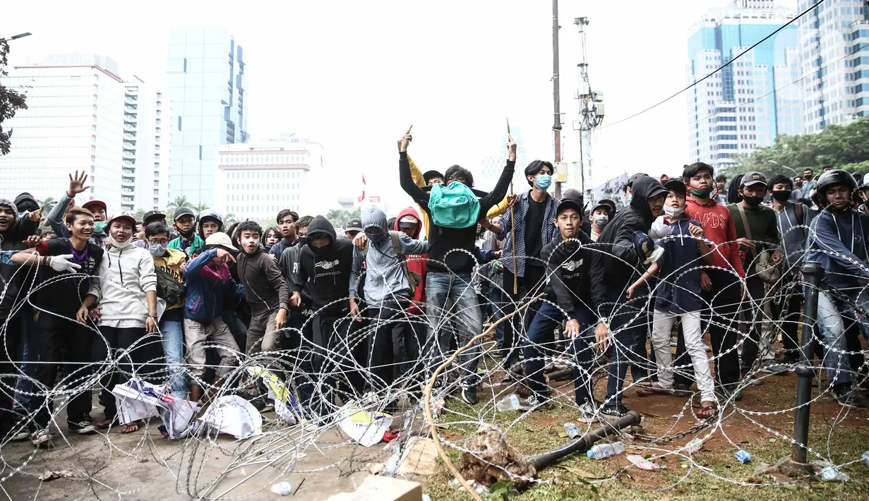 Pengunjuk rasa berupaya menerobos barikade polisi di kawasan Patung Kuda, Jakarta Pusat, Selasa (13/10/2020). Bentrokan antara massa aksi menolak UU Cipta Kerja dan kepolisian pecah. (Liputan6.com/Faizal Fanani)