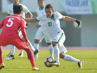Gelandang Timnas Indonesia U-19, Egy Maulana (kanan) berusaha melewati pemain Korea Selatan, Kim Hyunwoo pada laga ketiga kualifikasi Piala Asia U-19 2018 di Paju Public Stadium, Korsel (4/11). Timnas kalah 4-0 dari Korsel. (AFP Photo/Kim Doo-Ho)