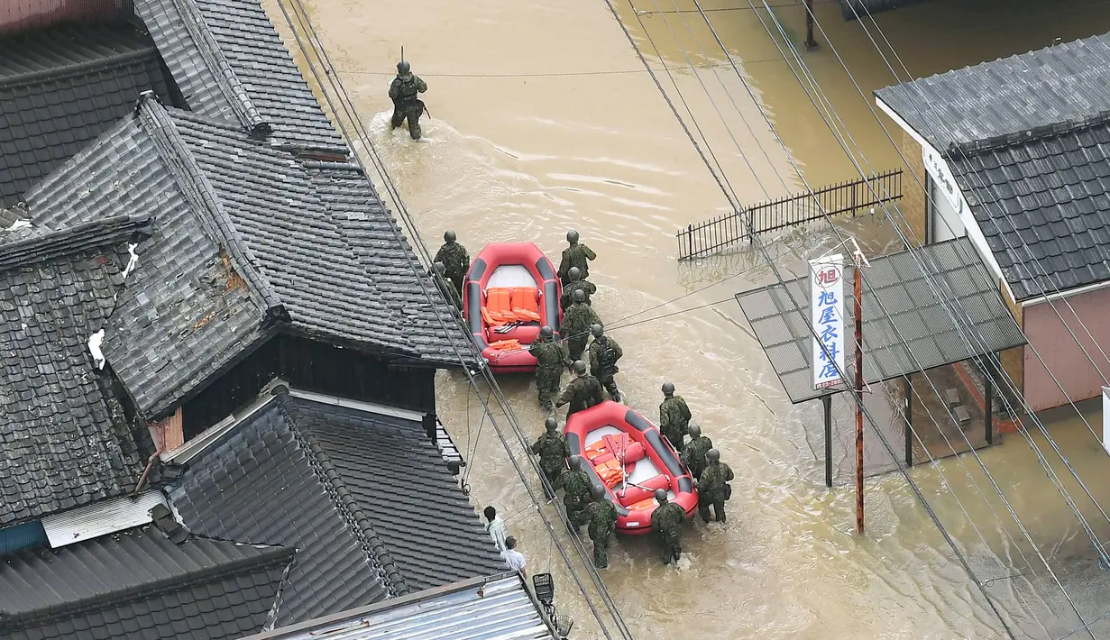 Pasukan Bela Diri Jepang menyusuri banjir saat melakukan penyelamatan di Takeo, Prefektur Saga, Jepang, Rabu (28/8/2019). Otoritas Jepang merilis perintah evakuasi bagi 240 ribu warga di kawasan barat daya yang diprediksi akan diterjang banjir dan tanah longsor. (Kyodo News via AP)