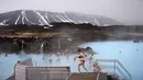 Sejumlah warga berenang menikmati sumber air panas di Myvatn, Islandia (12/4). Pemandangan sekitarnya didominasi oleh bentang alam vulkanik, termasuk pilar lava dan ventilasi tanpa akar (pseudocrater).  (AFP Photo/Loic Venance)