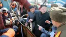 Pemimpin Korea Utara, Kim Jong-un menyimak keterangan pejabatnya saat menyaksikan langsung proses pemilahan ikan di stasiun perikanan di Pyongyang, Kamis (17/11). (REUTERS/KCNA)