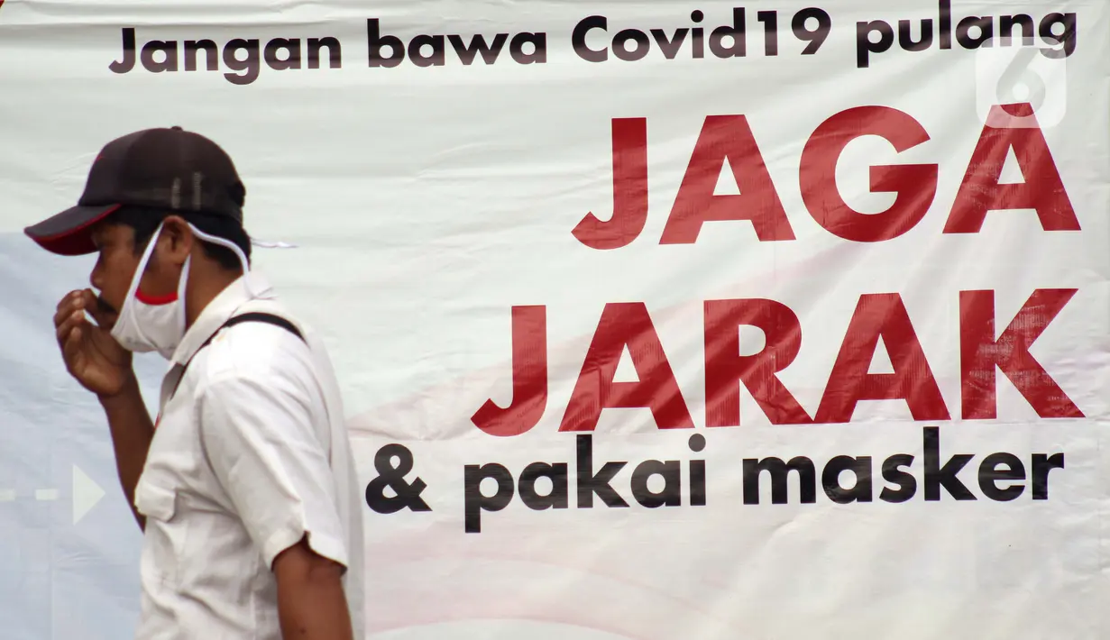 Warga melintas di depan spanduk sosialisasi pencegahan COVID-19 di kawasan Kemang, Jakarta, Kamis (9/7/2020). Berdasar data yang diumumkan pemerintah pada Kamis (9/7) ada penambahan 2.657 orang yang terinfeksi COVID-19 sehingga jumlah penderita menjadi 70.736. (Liputan6.com/Helmi Fithriansyah)
