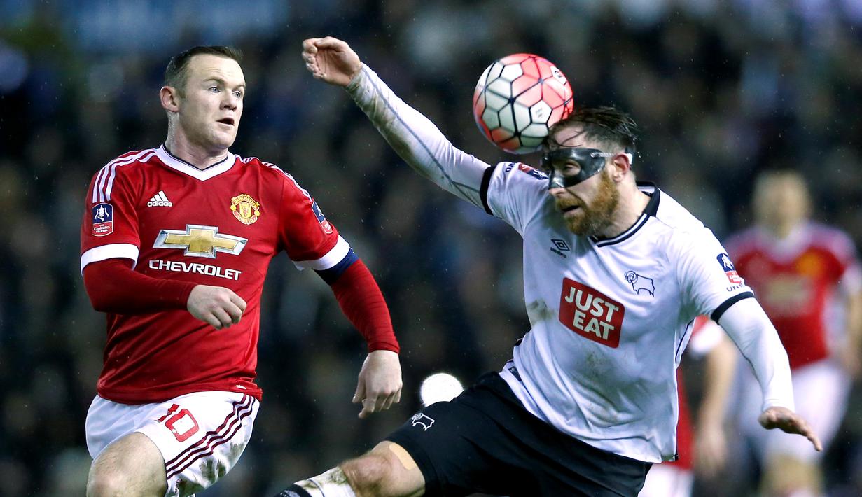 Striker Manchester United, Wayne Rooney, berebut bola dengan pemain Derby County, Richard Keogh pada laga putaran keempat Piala FA, di Stadion Pride Park, Sabtu (30/1/2016) dini hari WIB. (Reuters/Eddie Keogh)