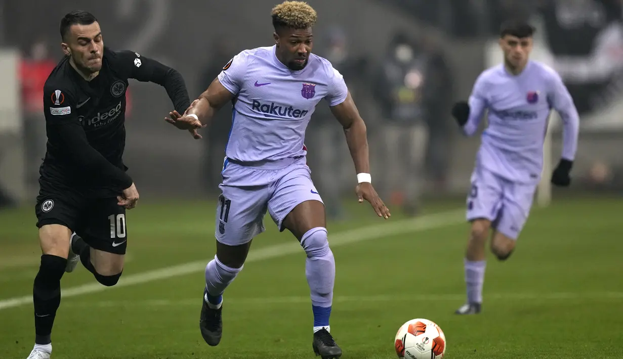 Penyerang Barcelona Adama Traore (tengah) berebut bola dengan gelandang Eintracht Frankfurt Filip Kostic pada laga leg pertama perempat final Liga Europa 2021/22 di Deutsche Bank Park, Jumat dini hari WIB (8/4/2022). Frankfurt dan Barcelona berbagi skor 1-1 . (AP Photo/Michael Probst)