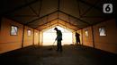 Pekerja membersihkan tenda darurat untuk ruang isolasi di Rumah Lawan COVID (RLC) Serpong, Tangerang Selatan, Kamis (11/2/2021). Pemkot Tangsel membangun tenda darurat berkonsep Tenda Glamour Camping (glamping) untuk menampung pasien Covid-19 di pusat karantina itu. (Liputan6.com/Angga Yuniar)