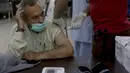 Petugas kesehatan menyuntikkan vaksin virus Corona Sinopharm kepada seorang pria lanjut usia (lansia) di pusat vaksinasi di Karachi, Pakistan, Rabu (10/3/2021). Pakistan telah mulai memvaksinasi orang yang berusia 60 tahun ke atas untuk melindungi mereka dari COVID-19 (AP Photo/Fareed Khan)