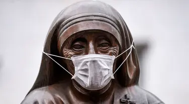 Masker terpasang pada wajah patung Bunda Teresa di Pristina, Kosovo, Kamis (19/12/2019). Pristina dan beberapa kota di Kosovo mengalami polusi udara tingkat tinggi. (Armend NIMANI/AFP)