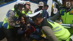 Petugas polisi berusaha mengamankan seorang wanita saat terjadi aksi demo di Jalan Medan Merdeka Barat, Jakarta, Rabu (28/3). Para driver taksi online ini menuntut Permenhub Nomor 108 Tahun 2017 dicabut. (Merdeka.com/Imam Buhori)