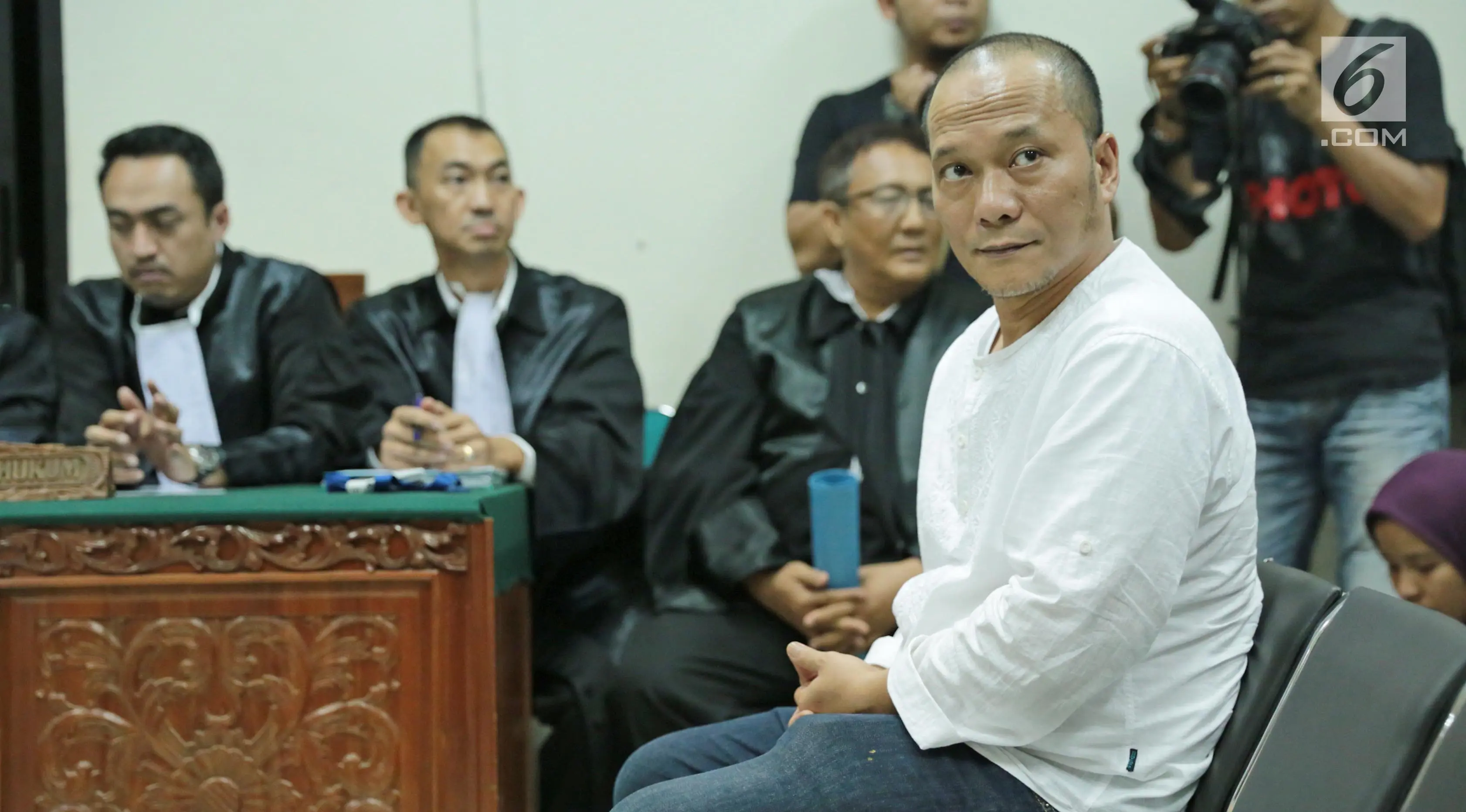 Rapper Iwa K duduk diruangan saat menjalani sidang perdana di Pengadilan Negeri Tangerang, Rabu (6/9). Pelantun 'Nombok Dong' tersebut terbukti membawa ganja seberat 1,485 gram dalam 3 linting rokok. (Liputan6.com/Pool)
