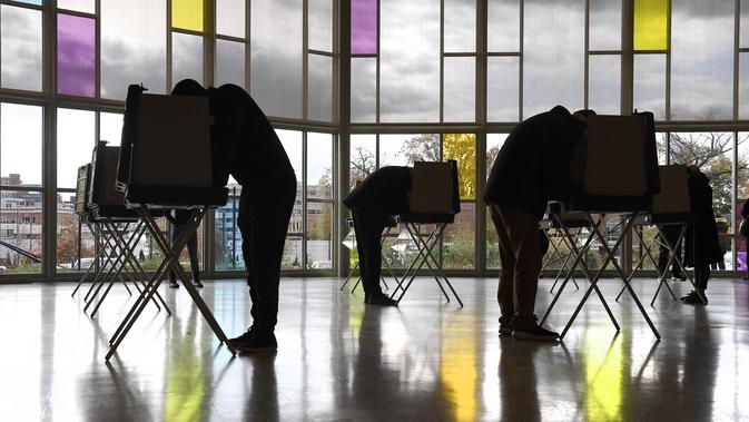 Para pemilih menandai surat suara mereka di Gereja First Presbyterian pada Hari Pemilihan di Stamford, Connecticut, Amerika Serikat, Selasa (3/11/2020). (AP Photo/Jessica Hill)
