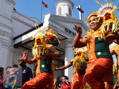 Peserta mengenakan pakaian adat saat mengikuti Karnaval Lintas Budaya, Semarang, Minggu (27/3). Masyarakat menyambut antusias acara karnaval tersebut dengan berjejer di tepi jalan. (Foto: Gholib)