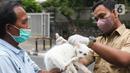 Petugas menyutikan vaksin rabies kepada kucing di Pasar Barito, Jakarta, Senin (28/3/2022). Sudin KPKP Jakarta Selatan melakukan inspeksi kesehatan hewan di Pasar Barito meliputi penyemprotan disinfektan, pemeriksaan kesehatan hewan dan vaksinasi rabies gratis. (Liputan6.com/Herman Zakharia)