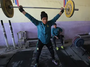 Atlet angkat besi wanita Irak Hadeel Salem Al-Saedi berlatih di sebuah klub di Kota Sadr, sebelah timur Baghdad, Irak (18/1). Para atlet wanita ini berlatih dengan giat tiap harinya. (AFP Photo/Ahmad Al-Rubaye)