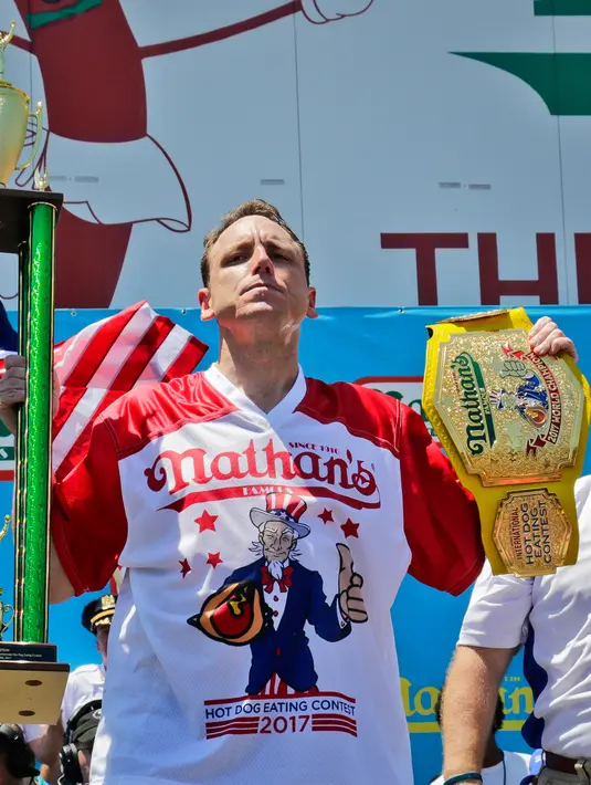 Joey Chestnut mengangkat trofi usai memenangkan Lomba Makan Hot Dog Nathans di New York, AS (4/7). Joey Chestnut menang untuk kesepuluh kalinya sekaligus mencetak rekor baru. (AP Photo/Bebeto Matthews)