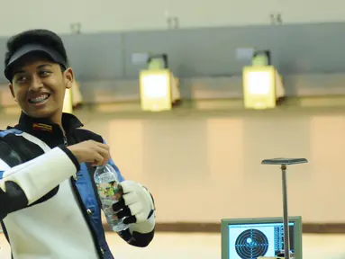 Petembak Junior Indonesia, Fathur Gustafian tersenyum usai memastikan tempat kedua Final 10m Air Rifle Men Junior Kejuaraan Menembak ASEAN di Jakarta, Selasa (24/11/2015). Fathur kalah 2.8 poin dari petembak Singapura. (Liputan6.com/Helmi Fithriansyah)