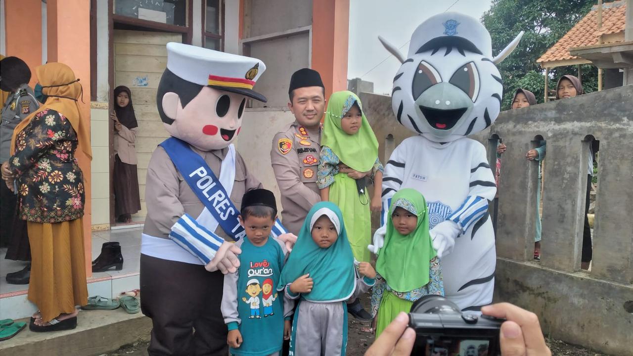 Kapolres Tasikmalaya AKBP Rimsyahtono berfoto bersama maskot tertib berlalu lintas dengan anak-anak usia 6-11 tahun peserta vaksinasi Covid-19.