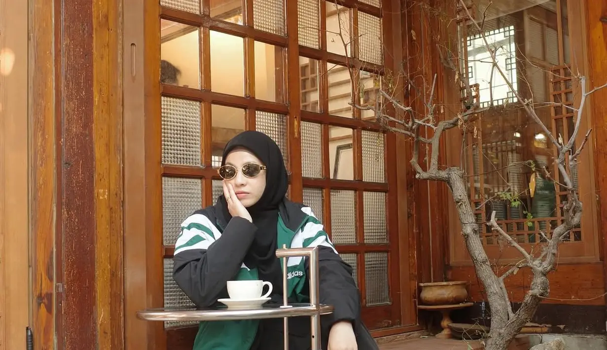 Natasha Rizky tampil dengan jaket hijau dipadukan inner dan rok hitam, senada dengan kerudungnya. Ia pun mengenakan kacamata hitam. Dipadukan sepatu Puma hitam.  [@natasharizkynew]
