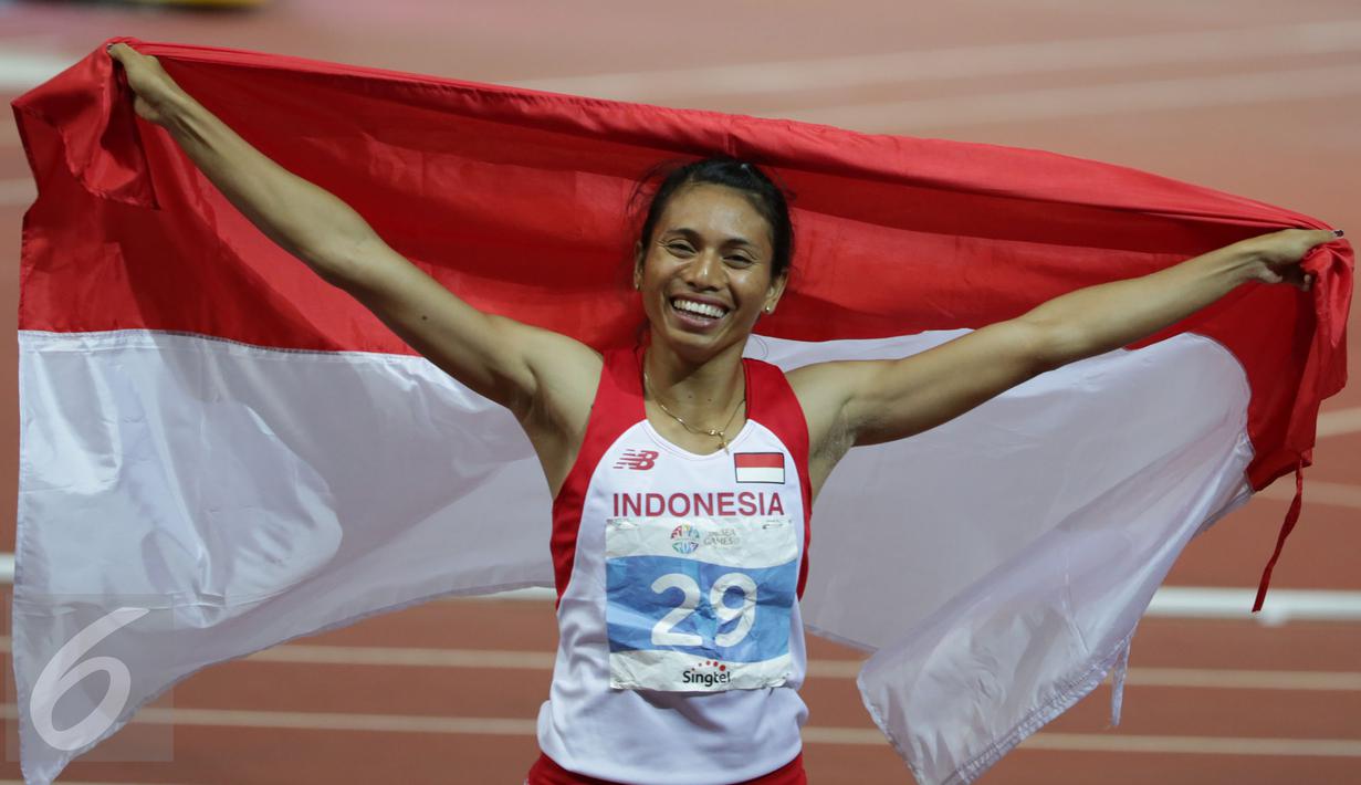 Atlet putri Indonesia, Maria Londa melakukan selebrasi usai memastikan meraih emas cabang atletik nomor lompat jangkit di National Stadium, Singapura, Kamis (11/6/2015). Maria mencatat lompatan sejauh 13,75 meter. (Liputan6.com/Helmi Fithriansyah)