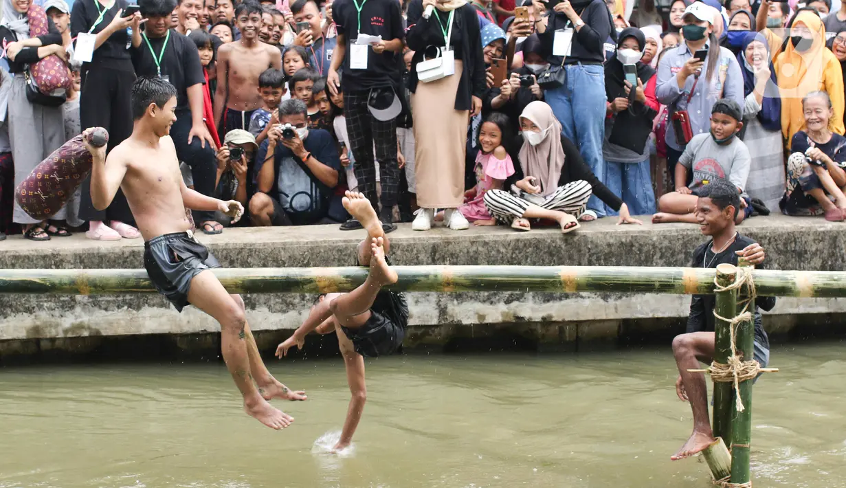 Dua orang anak mengikuti perlombaan pukul bantal di aliran Kalimalang, Jakarta Timur, Sabtu (27/8/2022). Perlombaan di Kalimalang yang diselenggarakan kembali setelah dua tahun berhenti akibat pandemi covid-19 ini untuk memeriahkan peringatan HUT ke-77 Kemerdekaan RI. (Liputan6.com/Herman Zakharia)