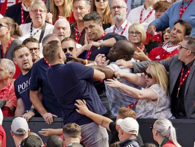 Sesama suporter Manchester United terlihat adu jotos saat menyaksikan tim kesayanganya tampil melawan Brighton and Hove Albion pada laga Liga Inggris di Stadion Old Trafford, Minggu (07/08/2022). (AP/Dave Thompson)