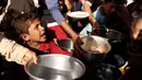 Sejumlah anak saat mengambil makanan saat mengungsi di kamp Khazer, Irak, (11/11). Warga terpaksa melarikan diri saat Pasukan Irak dan kelompok militan ISIS bentrok memberebutkan kota Mosul. (REUTERS/Zohra Bensemra)