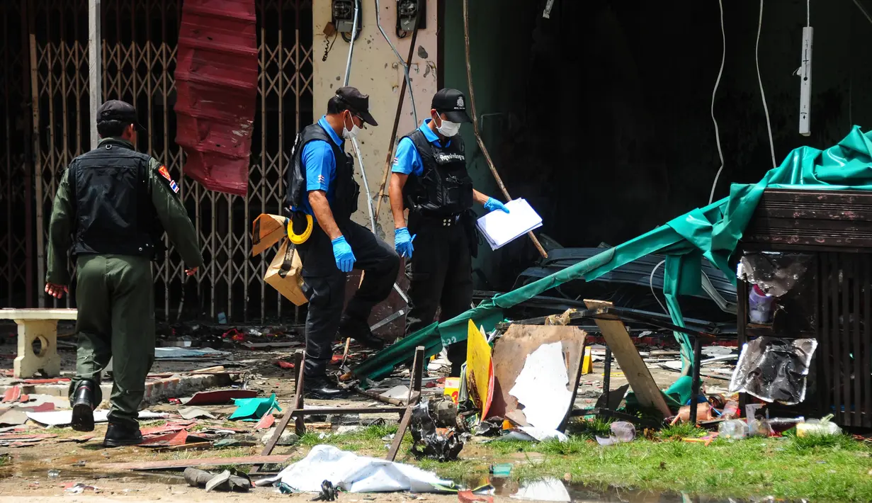 Polisi memeriksa lokasi ledakan bom motor di luar sebuah sekolah di distrik Tak Bai, Thailand, Selasa (6/9). Bom itu meledak ketika seorang ayah mengantarkan putrinya yang berusia 4 tahun ke sekolah hingga menyebabkan keduanya tewas. (Madaree TOHLALA/AFP)