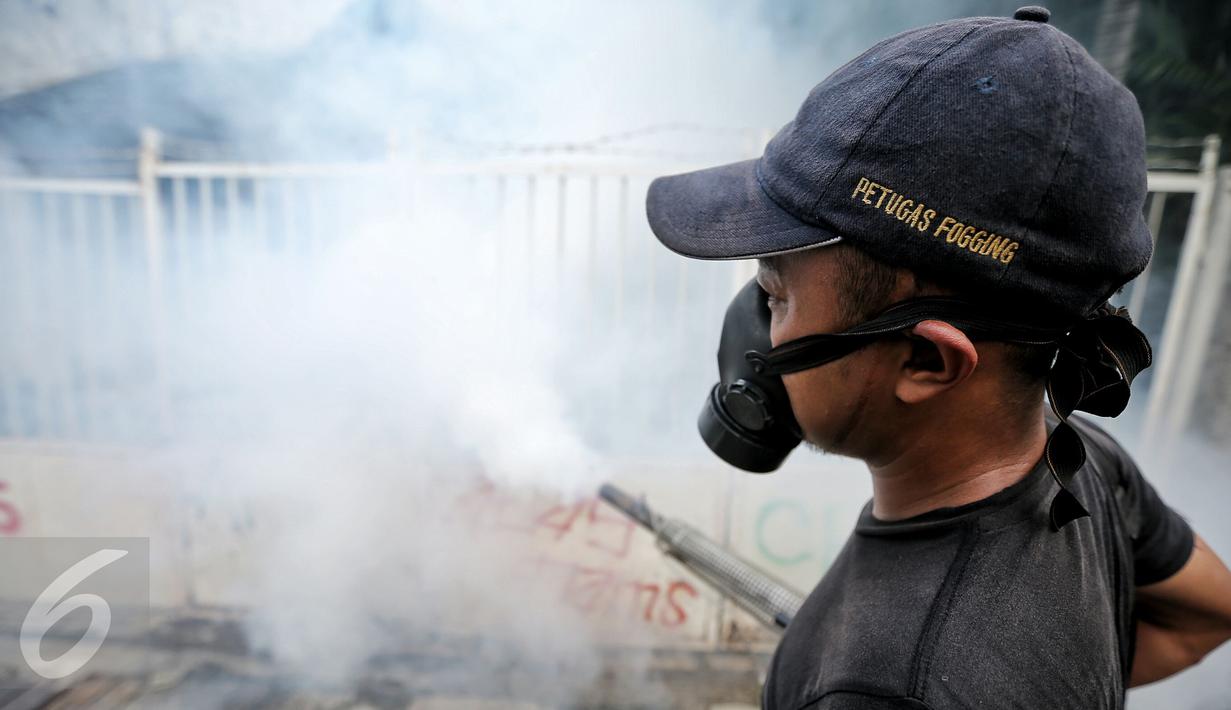 Petugas melakukan pengasapan (fogging) di kelurahan Menteng, Jakarta, Senin (8/2). Pengasapan oleh petugas puskesmas setempat itu dilakukan untuk mencegah wabah penyakit demam berdarah yang kerap muncul pada peralihan musim. (Liputan6.com/Faizal Fanani)