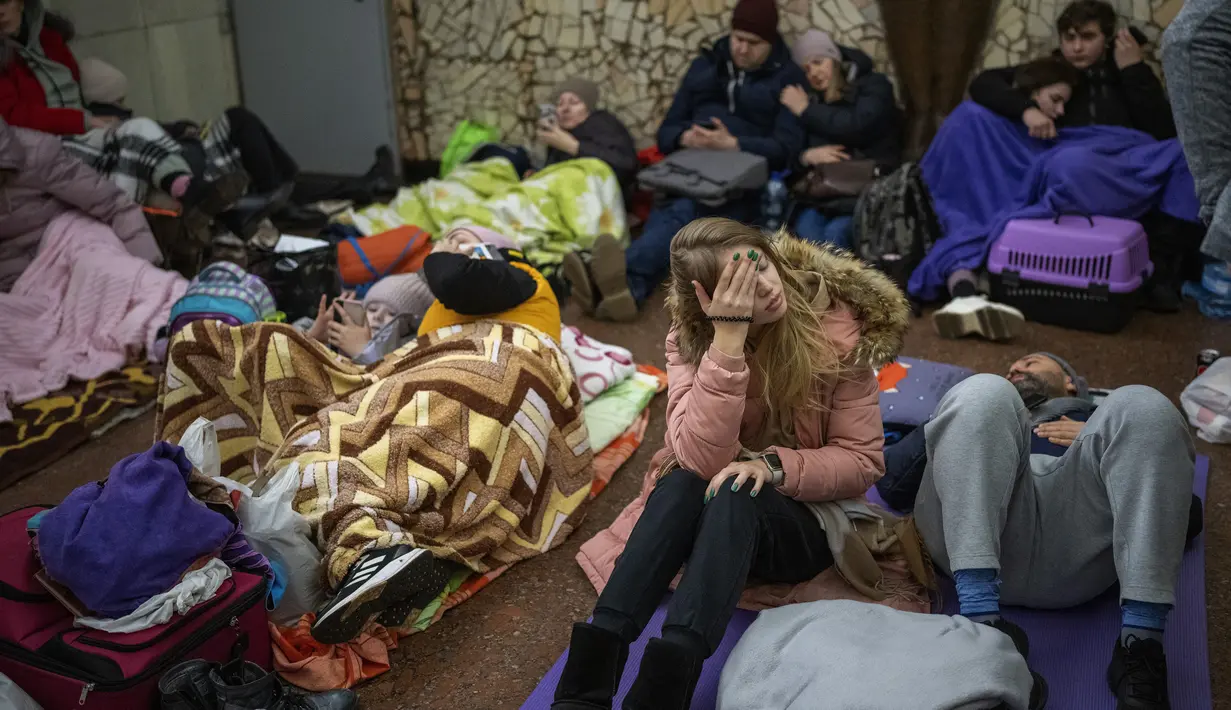 Orang-orang beristirahat di kereta bawah tanah Kiev yang digunakan sebagai tempat perlindungan bom di ibu kota Ukraina, Kamis, 24 Februari 2022. Warga di Kiev tampak berlindung di stasiun bawah tanah kota dan tempat-tempat aman lainnya untuk menghindari invasi Rusia. (AP Photo/Emilio Morenatti)