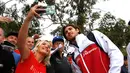 Pembalap F1 Alfa Romeo, Antonio Giovinazzi berselfie bersama penggemarnya saat tiba di Sirkuit Melbourne Grand Prix di Melbourne, Jumat (15/3). (Reuters/Edgar Su)