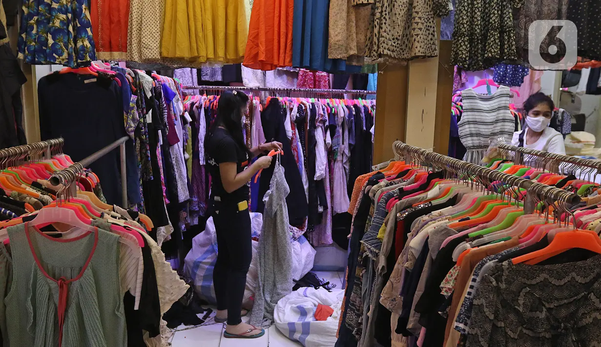Seorang wanita menata pakaian di kios pakaian bekas Pasar Senen Blok III, Jakarta, Kamis (11/6/2020). Pasar yang tetap buka saat PSBB dengan pembatasan jam operasional ini akan kembali dibuka secara normal pada 15 Juni 2020 dengan aturan protokol kesehatan COVID-19. (Liputan6.com/Herman Zakharia)