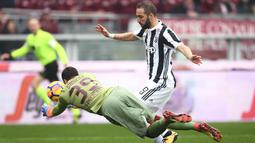 Kiper Torino, Salvatore Sirigu (kiri) mengamankan gawangnya dari penyerang Juventus, Gonzalo Higuain pada laga Serie A  di Stadio Grande Torino, Turin (18/2/2018). Juventus menang 1-0. (AFP/Marco Bertorello)