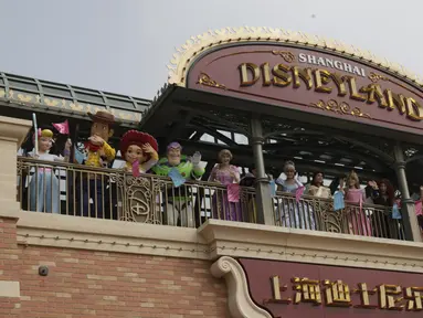 Karakter dan pegawai Disney menyambut wisatawan di taman hiburan Disneyland, Shanghai, China, Senin (11/5/2020). Walt Disney Co resmi membuka kembali Disneyland Shanghai mulai hari ini. (AP Photo/Chen Si)