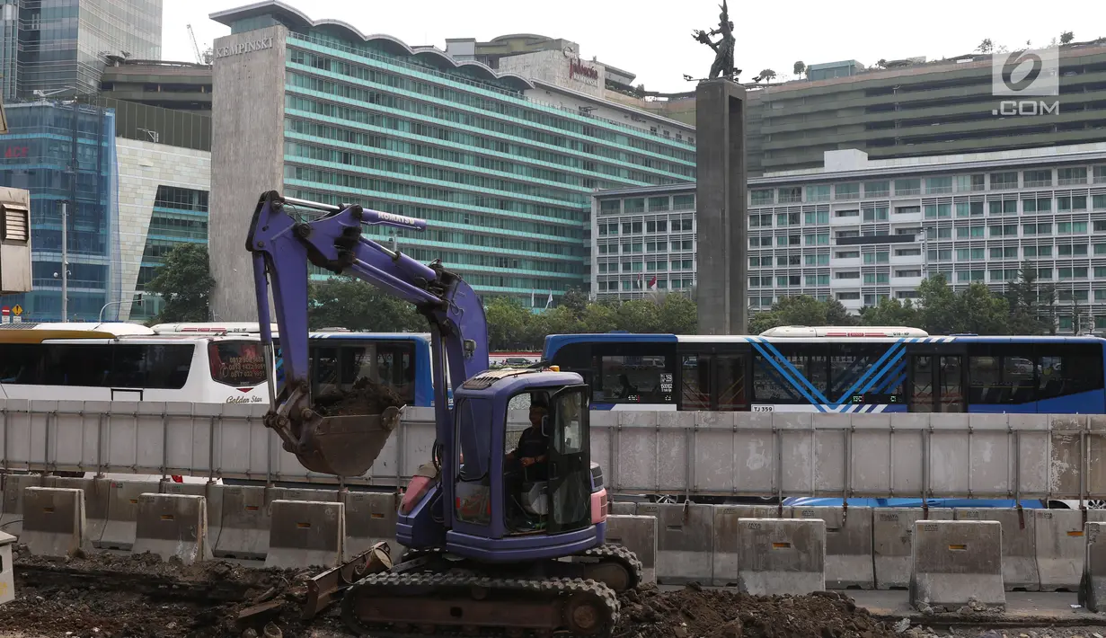 Pekerja dibantu alat berat mengerjakan proyek revitalisasi trotoar di kawasan Bundaran Hotel Indonesia, Jakarta, Selasa (24/9/2019). Pemprov DKI tengah mengebut pembangunan revitalisasi trotoar di sejumlah titik Ibu Kota yang ditargetkan rampung akhir 2019 mendatang. (Liputan6.com/Angga Yuniar)