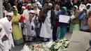 Sejumlah muslim meletakkan karangan bunga di Potters Field Park, London, Senin (5/6). Mereka mengenang dan mendoakan para korban serangan teror di London Bridge dan Borough Market yang menewaskan 7 orang dan melukai puluhan lainnya. (AP Photo/Tim Ireland)