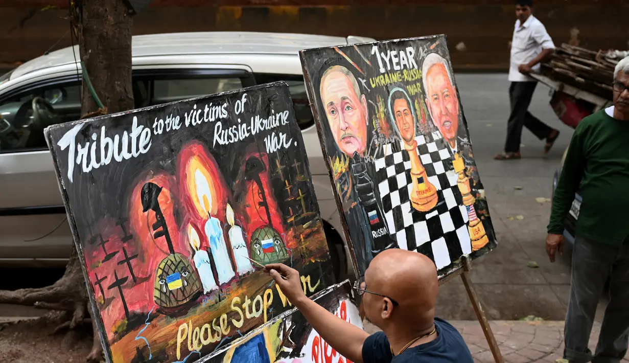 Warga melihat saat seorang seniman mengerjakan sebuah lukisan untuk memberikan penghormatan kepada para korban perang pada malam satu tahun invasi Rusia ke Ukraina, di Mumbai, India, Kamis 23 Februari 2023. Menurut Kantor Komisaris Tinggi PBB untuk Hak Asasi Manusia (OHCHR) per 21 Februari 2023, sedikitnya 8.006 non-kombatan tewas, sementara 13.287 orang terluka sejak invasi Rusia ke Ukraina pada 24 Februari 2022. (Punit PARANJPE/AFP)
