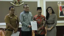 Menpan RB Syafruddin (kedua kiri) dan Bupati Kabupaten Solok Selatan Muzni Zakaria (kedua kanan) menunjukkan berkas CPNS dokter gigi Romi Syofpa Ismael di kantor Kemenpan RB, Jakarta, Senin (5/8/2019). (Liputan6.com/Angga Yuniar)