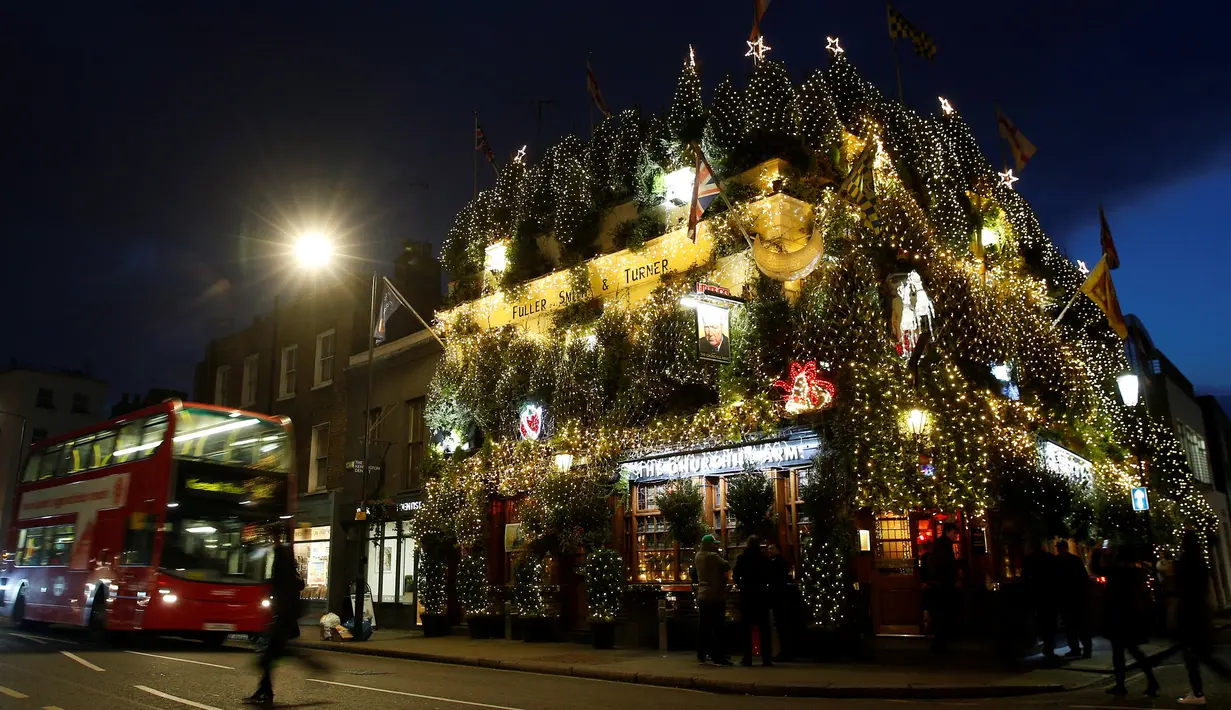 Pohon natal menutupi bagian luar bangunan bar The Churchill Arms di London, Inggris, 20 Desember 2016. Dalam rangka menyambut Natal, lebih dari 80 pohon natal dan hampir 22.000 lampu berkelap-kelip tampak menghiasi bar tersebut. (REUTERS/Neil Hall)