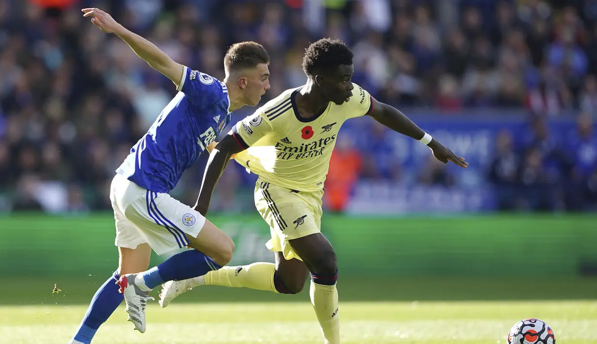Pemain Leicester City Luke Thomas (kiri) berebut bola dengan pemain Arsenal Bukayo Saka pada pertandingan Liga Inggris di Stadion King Power, Leicester, Inggris, 30 Oktober 2021. Arsenal menang 2-0. (Zac Goodwin/PA via AP)