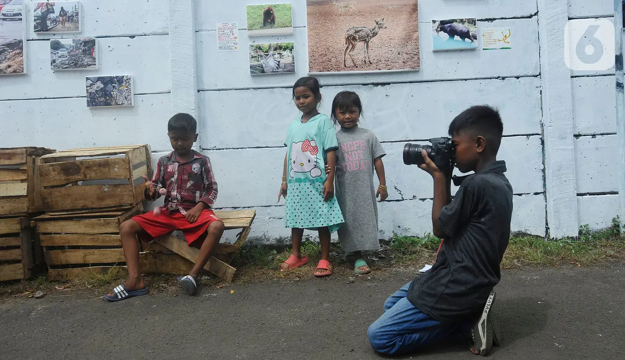 Anak-anak belajar memotret dengan kamera DSLR saat kegiatan pameran Lensa Anak Terminal di Sekolah Master, Depok, Jawa Barat, Rabu  (8/2/2023). Pameran 170 karya foto dari 12 anak-anak terminal di kawasan tersebut merupakan hasil pembelajaran bersama Komunitas Lensa Anak Terminal dan berlangsung  hingga 12 Februari 2023. (merdeka.com/Arie Basuki)