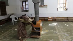 Seorang militan Houthi melakukan pemeriksaan pasca pemboman Masjid al-Balili, Yaman, Kamis (24/9/2015). Ledakan terjadi dua hari setelah Presiden Yaman, Abdrabbuh Mansour Hadi, kembali setelah diasingkan ke Arab Saudi. (REUTERS/Khaled Abdullah)