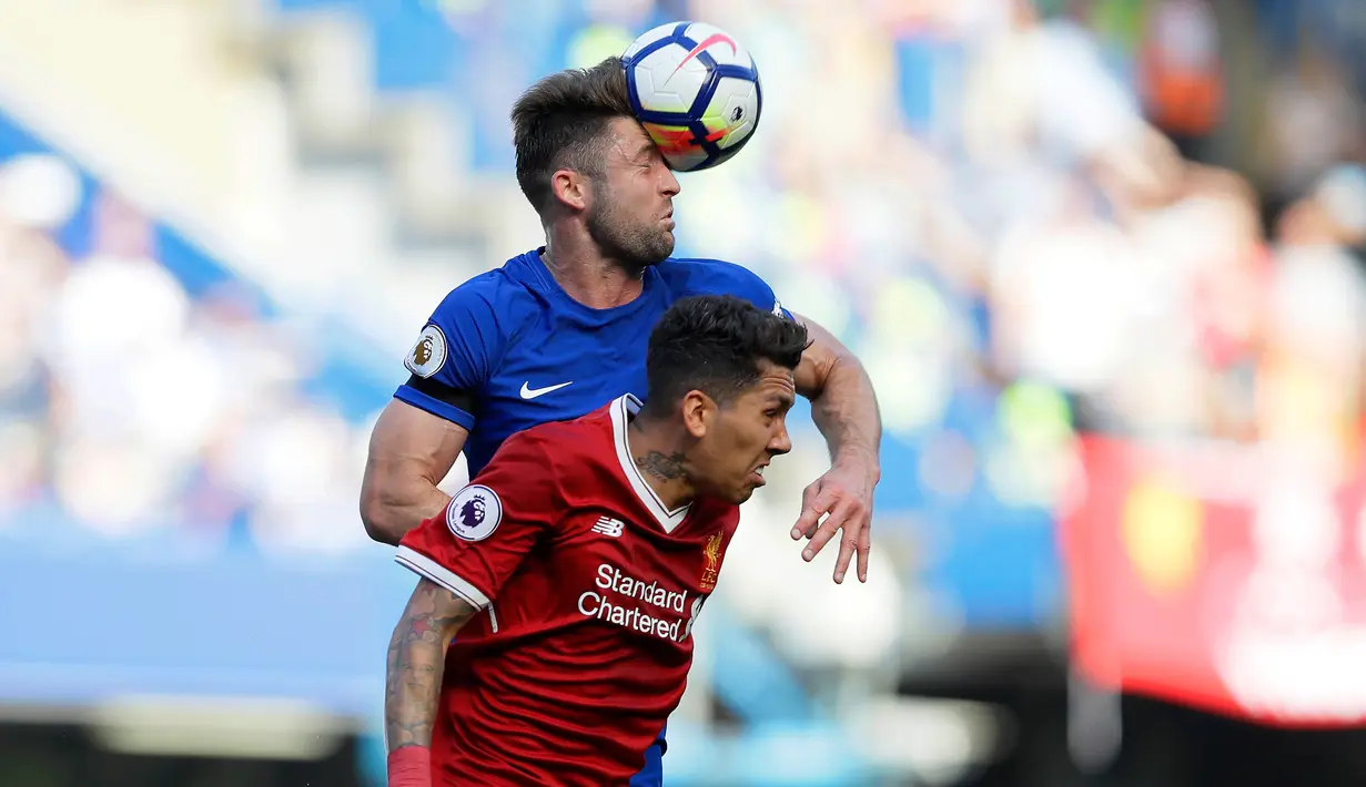 Bek Chelsea, Garyy Cahill berebut bola udara dengan pemain Liverpool Roberto Firmino selama pertandingan lanjutan Liga Inggris di Stamford Bridge di London (6/5). Chelsea menang tipis atas Liverpool 1-0. (AP Photo/Kirsty Wigglesworth)