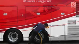 Petugas membersihkan bus transjakarta yang akan digunakan untuk pawai kemenangan tim sepak bola Persija Jakarta di kantor PT Transjakarta, Cawang, Kamis (13/12). Bus tersebut akan digunakan untuk pawai kemenangan Persija. (Liputan6.com/Immanuel Antonius)